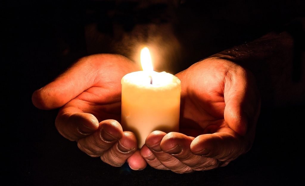 Hands holding a candle.