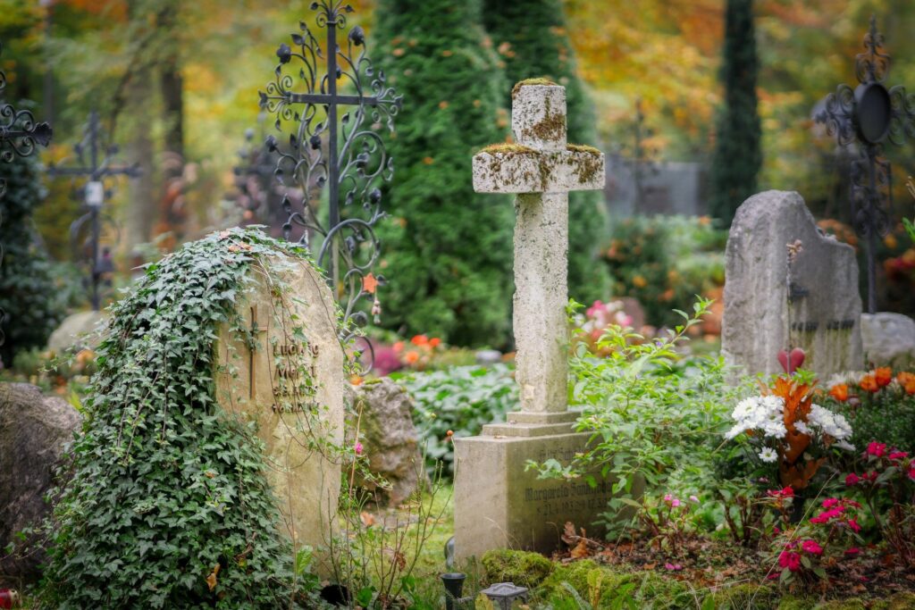 A cemetery with ivy and flowers growing over the headstones. Every1dies.org