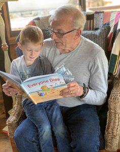 A grandpa reading Everyone Dies and yes, it is Normal to a young boy