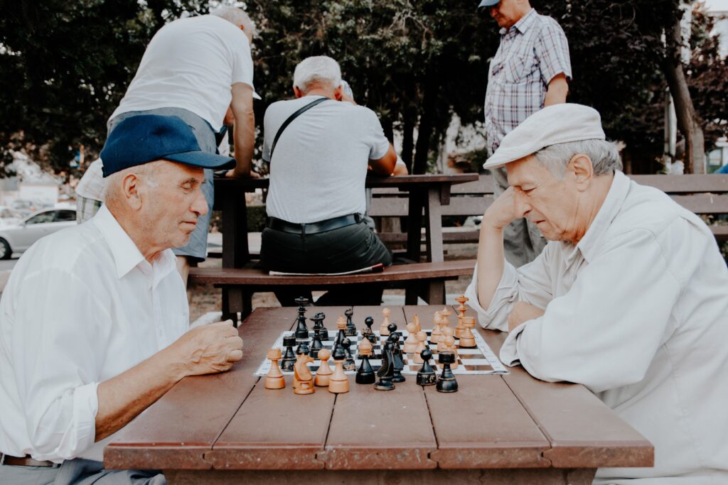 Two older men playing chess. Starting over to find new friends can be difficult, but well worth the rewards. Learn about finding new close friends as an adult in this episode.