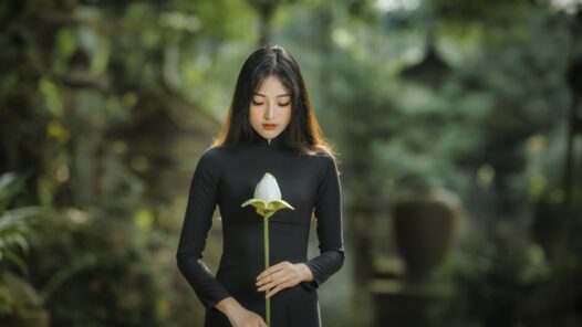 Young woman in long-sleeved black dress holding a flower. We talk about how a relationship changes when one becomes a caregiver for a partner, along with the tradition of black clothing
