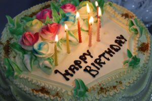 A birthday cake with multicolor flowers that says Happy Birthday. We talk about the good side of aging in this episode https://every1dies