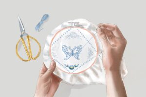 A butterfly being sewn in an embroidery hoop. Learn how people complete unfinished crafts after someone dies in this episode.