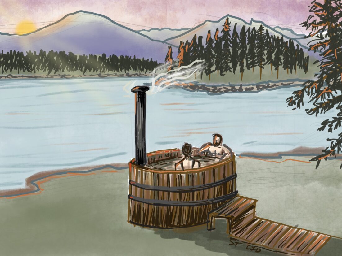 A couple enjoying a wood-fired hot tub on a lake beach with view of mountains and sunset. Learn about hot tub safety in this episode.