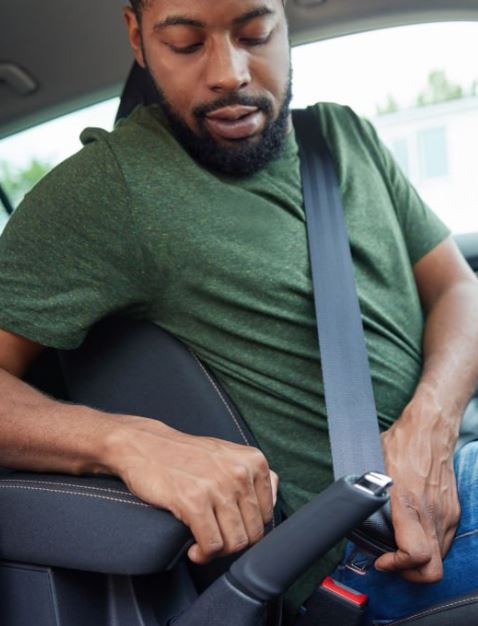 A man bucking a seat belt. We talk about how seat belts can increase survival 50% in a car accident