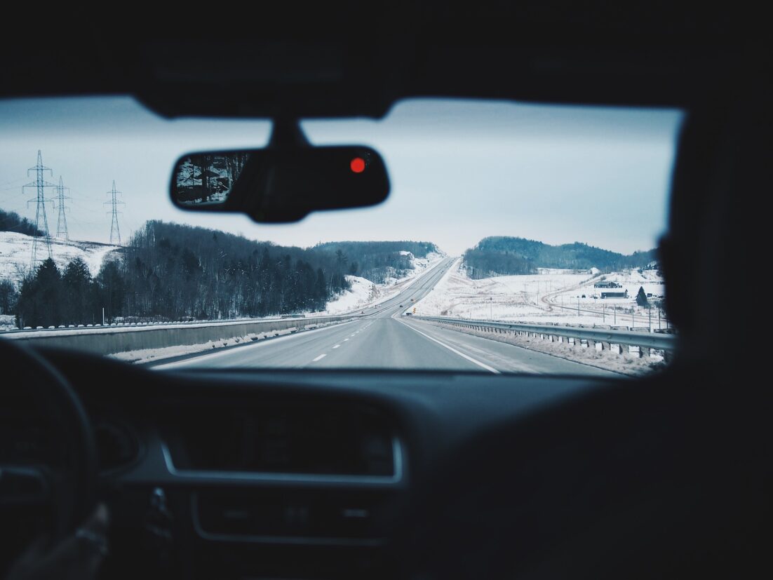 A view of a snowy road from inside a car. We talk about how to avoid a car accident in this episode.