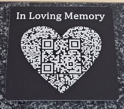 A QR code plaque on a gravestone, which leads to a digital memorial