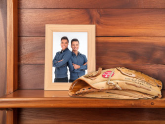 A wooden shelf with a photograph of two brothers and a worn baseball mitt. We talk about grieving the death of a sibling in this episode.