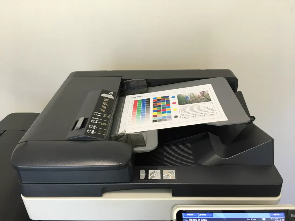 A photocopier with a printed paper on the top tray. We talk about the analogy of cancer cells duplicating to a broken copier making blurry or spotty photocopies.