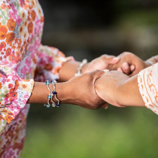 Two women gripping hands in support. Grief groups that incorporate mindful listening or even quiet companionship can be unexpectedly healing. Sometimes just breathing next to another person who gets it is enough. (Image source: Pixabay, AndPan614)