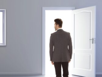 A man leaving a room through an open door. This represents the ghosting cancer patients and survivors experience by the relatives and friends they expected to support them through their journey.