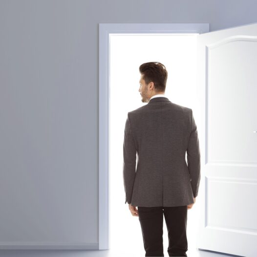 A man leaving a room through an open door. This represents the ghosting cancer patients and survivors experience by the relatives and friends they expected to support them through their journey.