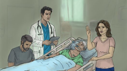 A doctor is delivering a poor prognosis to a family with an older man in the ICU. The woman is holding up her hand in disbelief. Optimistic bias by a family member charged with healthcare decisions can be a barrier for your wishes to be carried out.