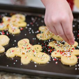 A child putting sprinkles on Christmas sugar cookies. Traditions such as these can be difficult to adapt when elders decline, but we talk about how to keep holidays special in this episode.