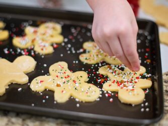 A child putting sprinkles on Christmas sugar cookies. Traditions such as these can be difficult to adapt when elders decline, but we talk about how to keep holidays special in this episode.