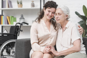 A senior woman and her daughter warmly holding hands