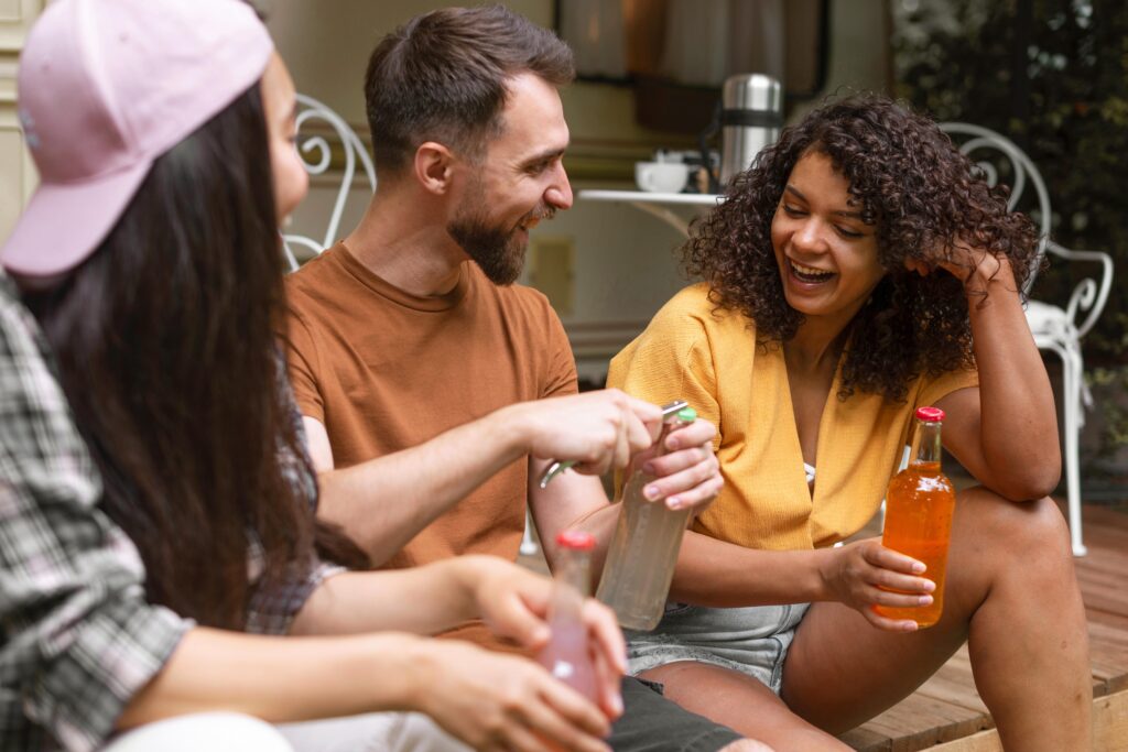 Three happy friends talking and sharing non-alcoholic drinks. We talk about Dru January and sober curious in this episode.