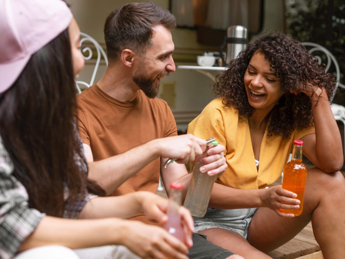 Three happy friends talking and sharing non-alcoholic drinks. We talk about Dru January and sober curious in this episode.