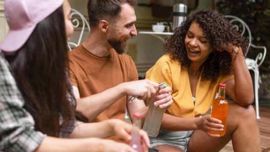 Three happy friends talking and sharing non-alcoholic drinks. We talk about Dru January and sober curious in this episode.