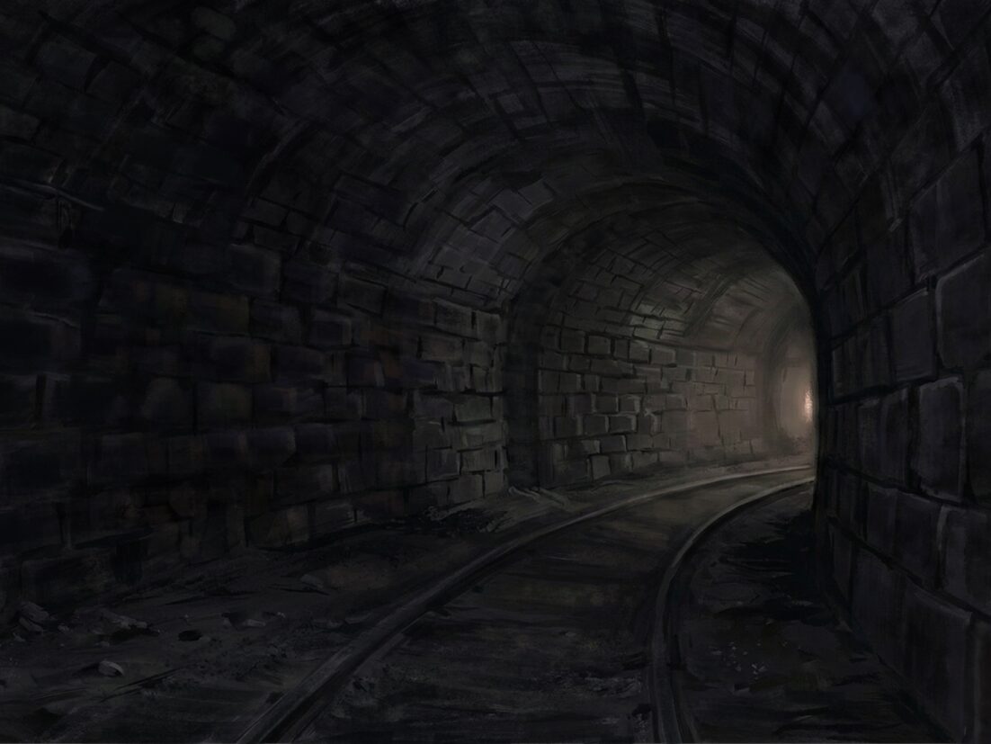 A lonely dark train tunnel with distant light.