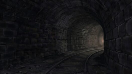 A lonely dark train tunnel with distant light.